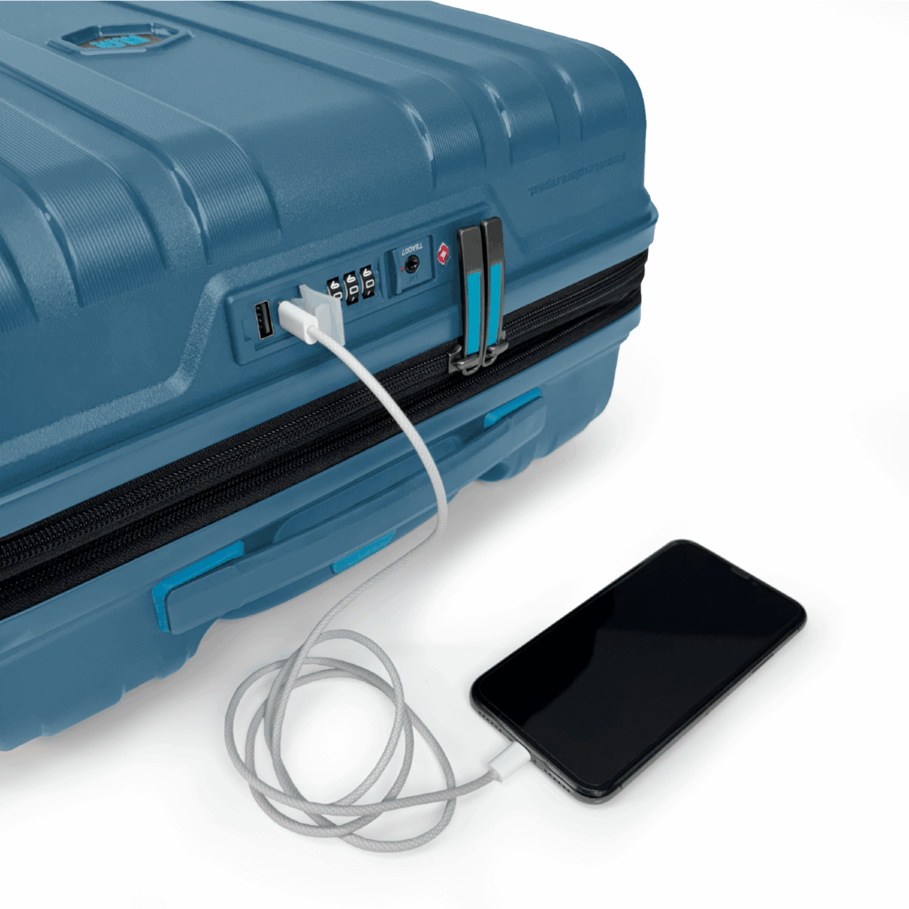 Close-up of a blue Ryanair power bank cabin bag with USB port, TSA lock, and charging cable connected to a mobile device.